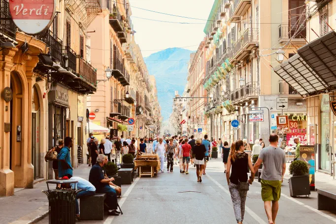 A busy shopping street lined with varied storefronts.