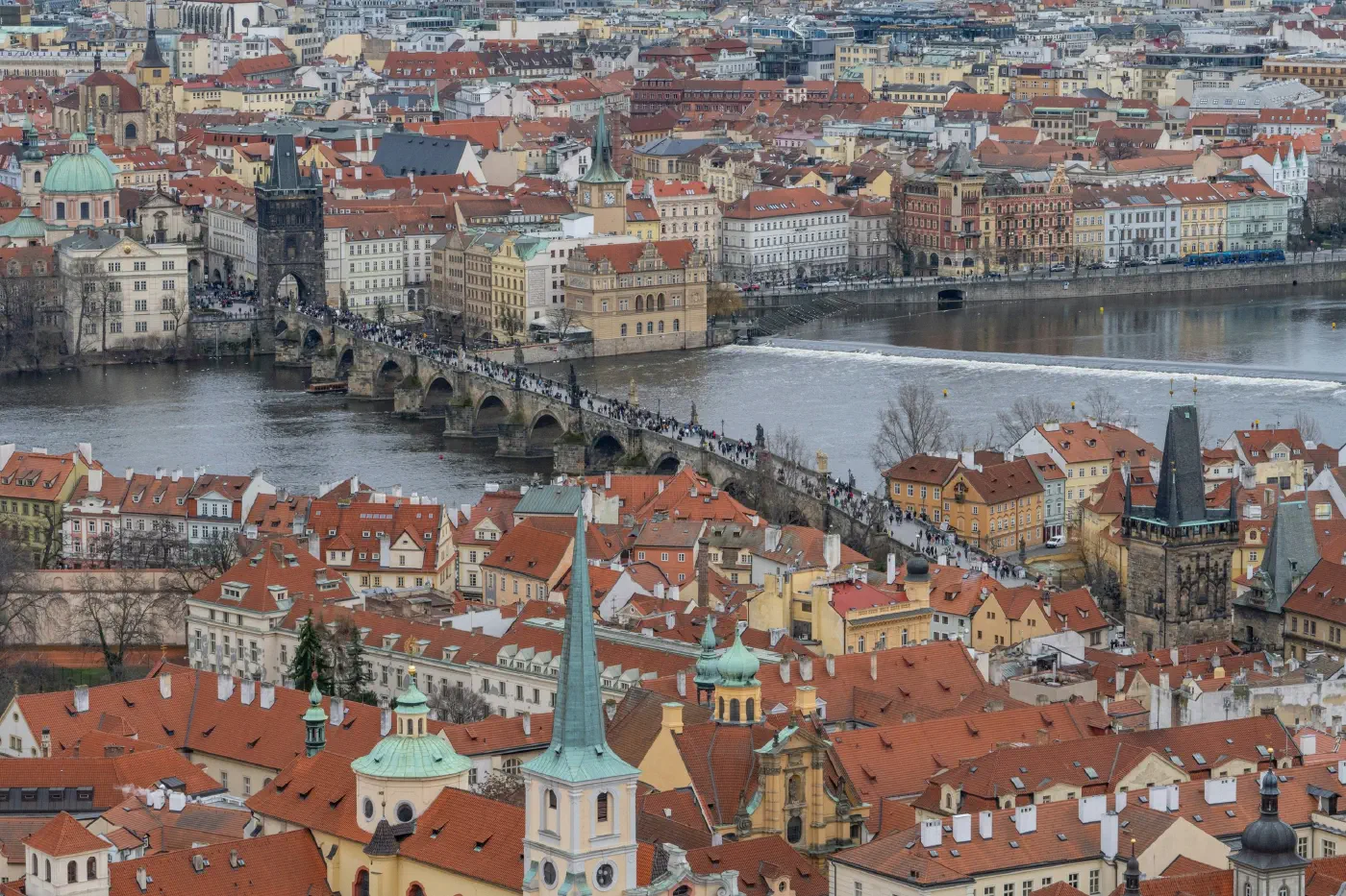 Aerial view over the historic centre of Prague, the Charles Bridge and red-tiled roofs that have channelled trade for centuries.